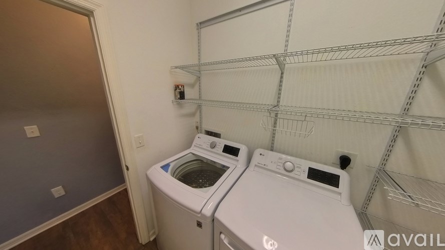A wall-mounted clothes drying rack is in a laundry room with two front-loading washing machines.