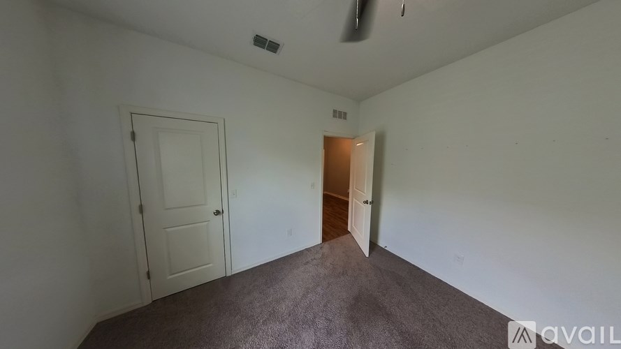 A room with a carpeted floor and two doors.