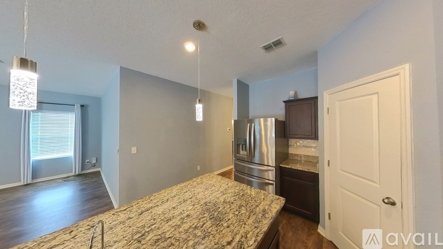 A kitchen area with a granite countertop and stainless steel appliances.