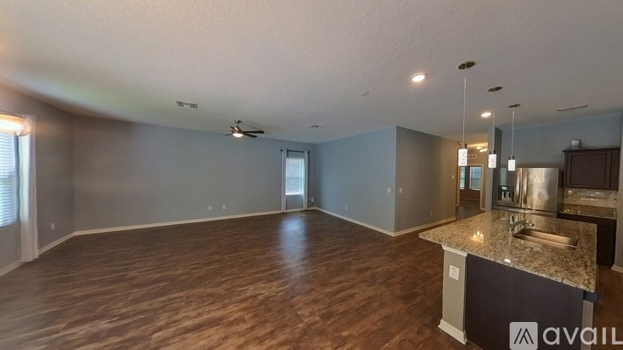 A spacious kitchen with a marble countertop and a ceiling fan.