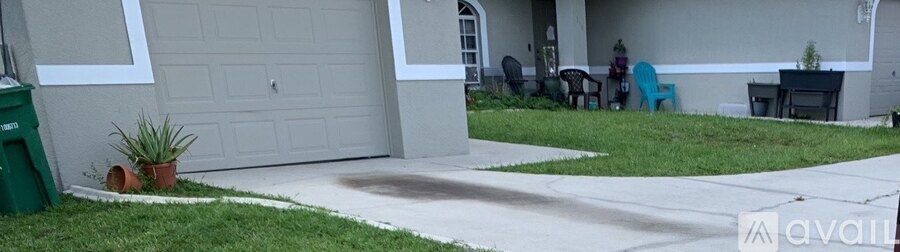 A house with a grey garage door and a white wall.
