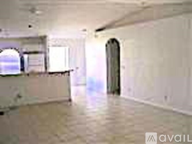 A spacious room with a doorway leading to another room.