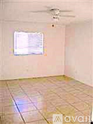 A room with a ceiling fan and a window.