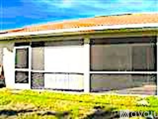 A white house with a brown roof and a window.