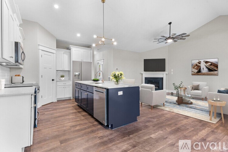 A modern kitchen with dark blue cabinets and a wooden floor.