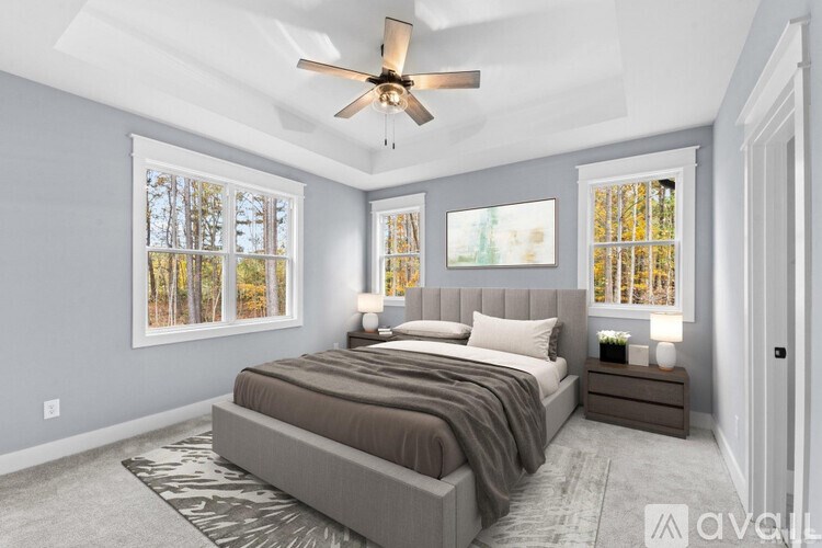 A bedroom with a large bed and a ceiling fan.