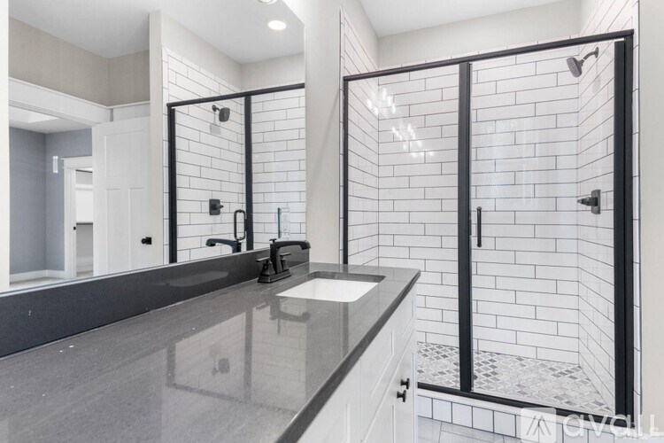 A modern bathroom with a black and white tile shower.