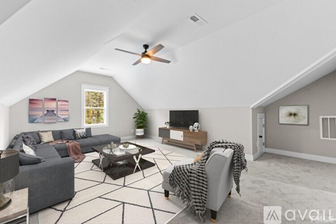 A living room with a grey couch and a black and white rug.