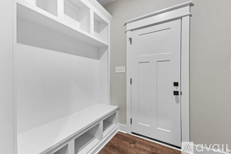 A white closet with a door and shelves.