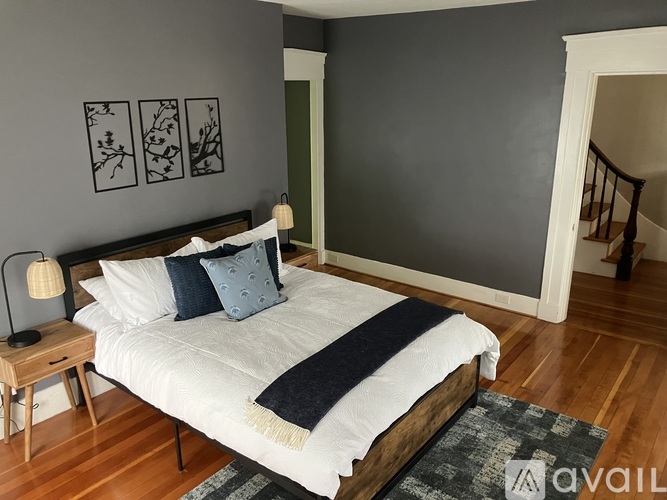 A bedroom with a bed, nightstand, and lamp.