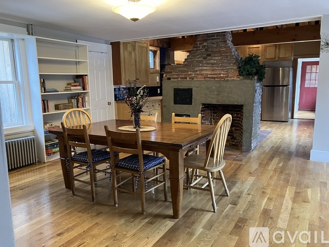 A dining room with a wooden table and chairs.