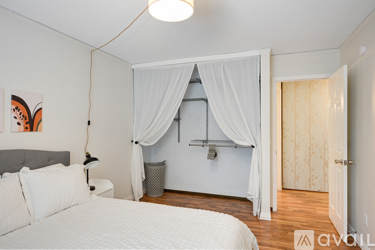 A bedroom with a bed, a canopy bed with a canopy, and a painting on the wall.