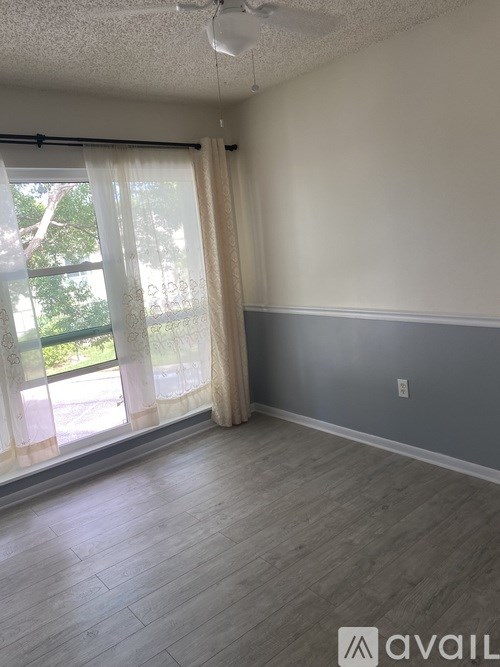 A room with a sliding glass door and a ceiling fan.