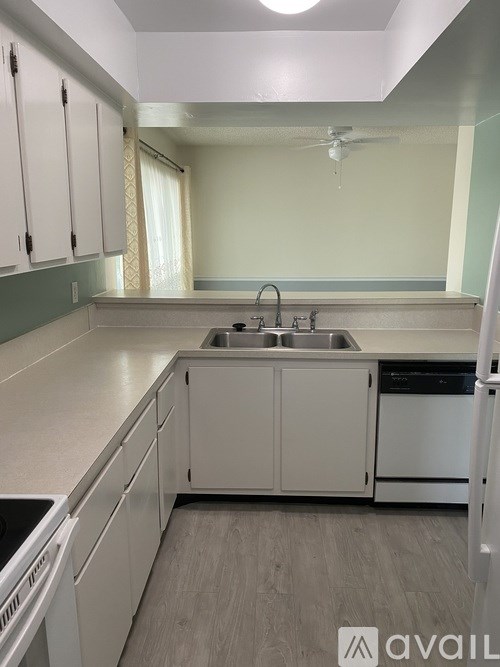 A kitchen with white cabinets and a stainless steel dishwasher.