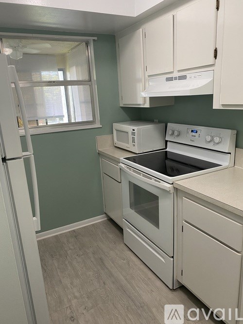 A kitchen with white appliances and cabinets.