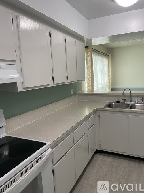A kitchen with white cabinets and a black stove top oven.