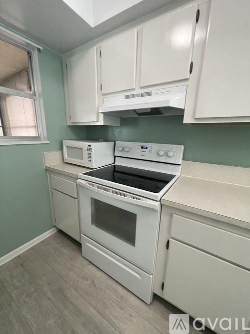 A bathroom with a grey tiled shower and a white shelf.