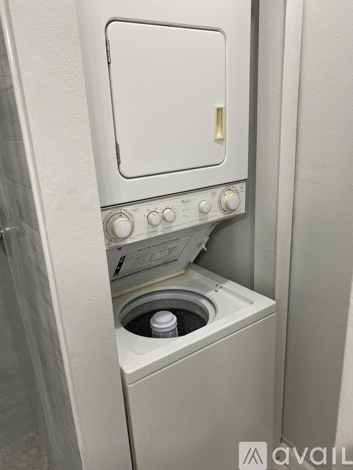 A white dishwasher with a control panel and a drain plug.