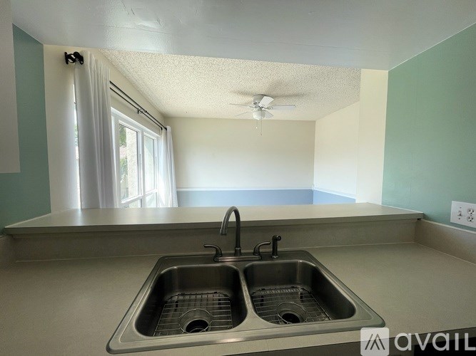 A white sink in a bathroom with a mirror above it.