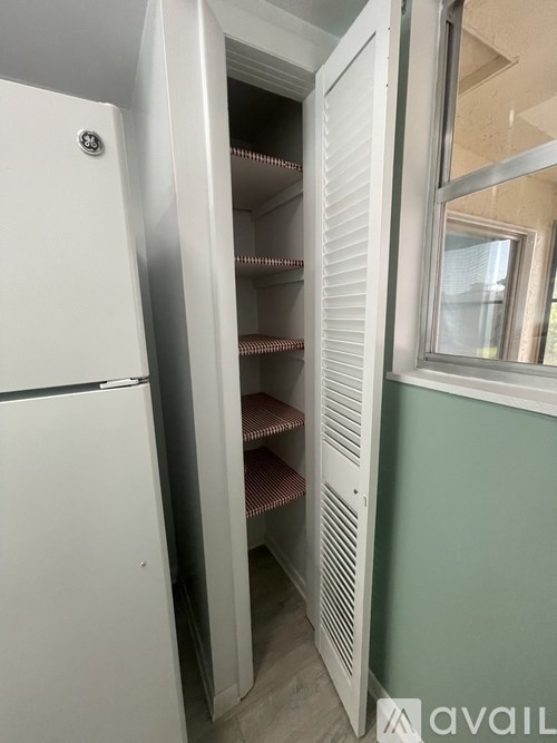 A room with a ceiling fan and a window with blinds.