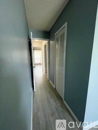 A room with a ceiling fan and a window with blinds.