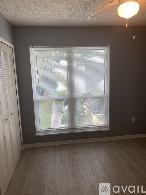 A room with a window and a wooden floor.