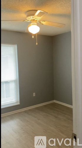 A room with a ceiling fan and a window.