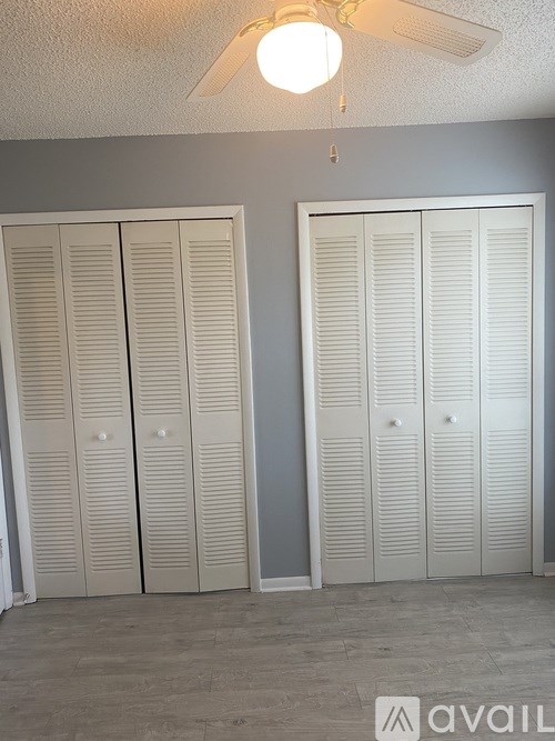 Three white closet doors in a room.