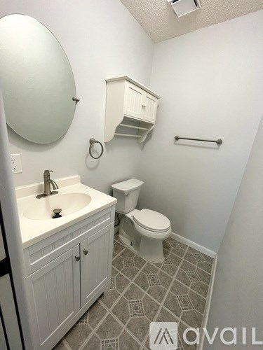 A serene waterfront scene with a dock and houses in the distance.