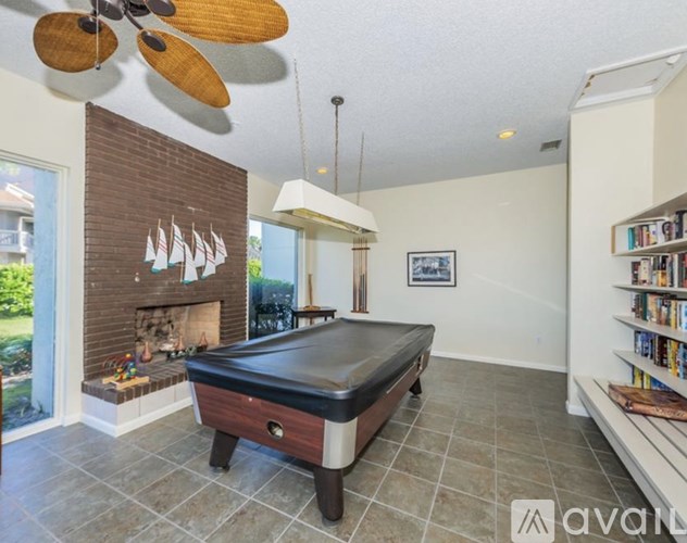 A room with a pool table and a fireplace.