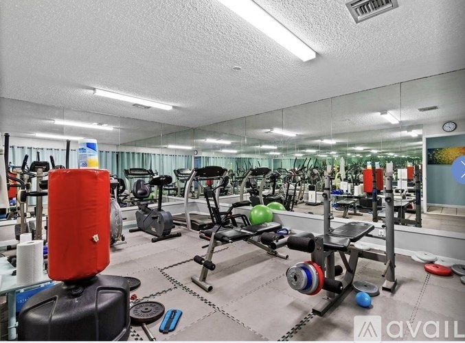 A gym with a variety of equipment including weights and cardio machines.