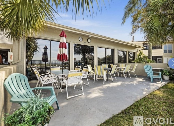 A patio with chairs and a table is set up outside a building.