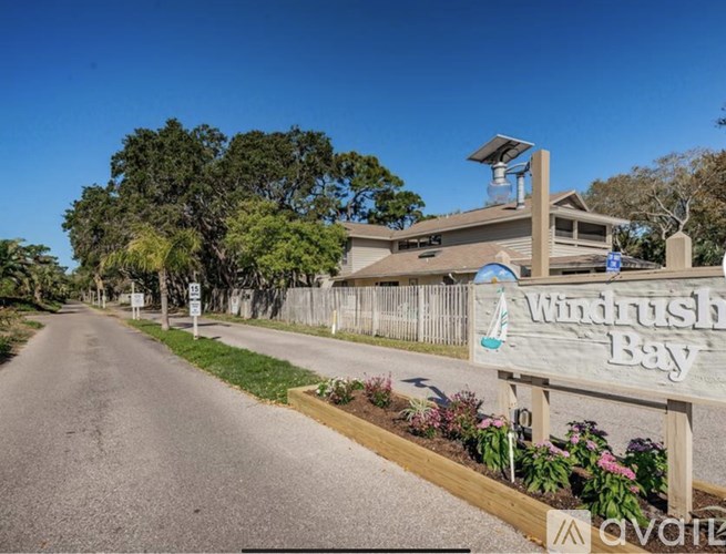 A sign for Windrush Bay is on the side of a road.