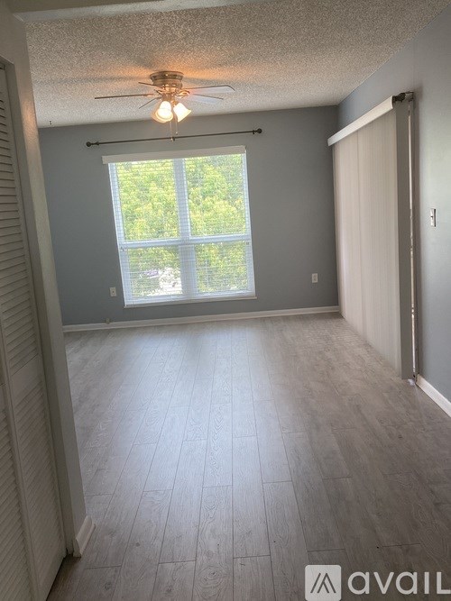A room with a window and a ceiling fan.