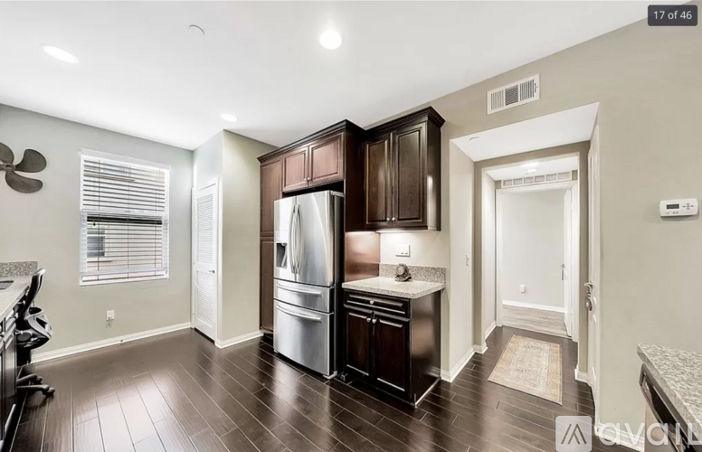 A kitchen with dark wood cabinets and a stainless steel refrigerator.