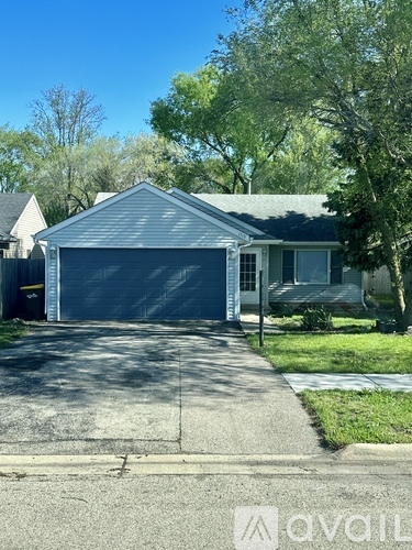 A house with a garage and a driveway in front.