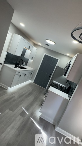 A modern kitchen with a refrigerator, sink, and cabinets.