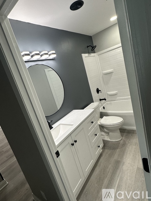 A bathroom with a toilet, sink, and mirror.