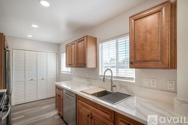 A kitchen with wooden cabinets and a marble countertop.