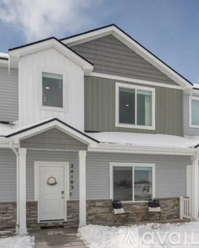 A house with a grey and white exterior and a white door.