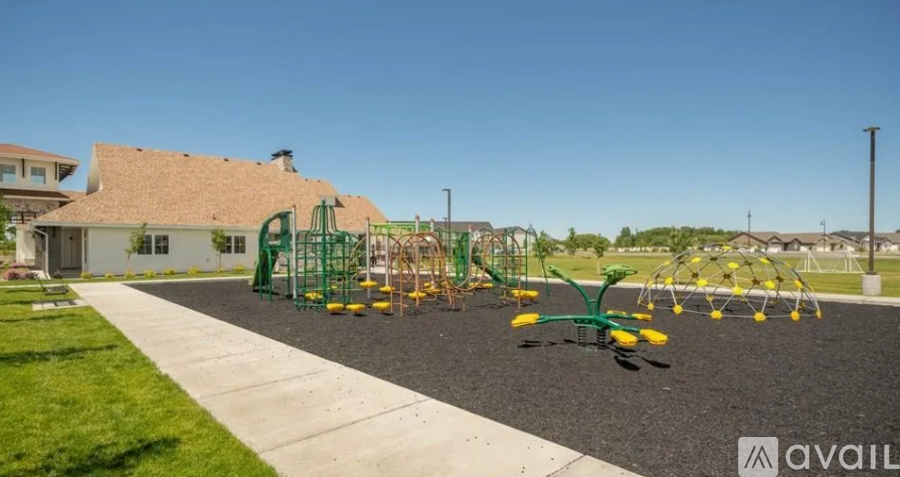 A playground with a green swing set and a yellow slide.