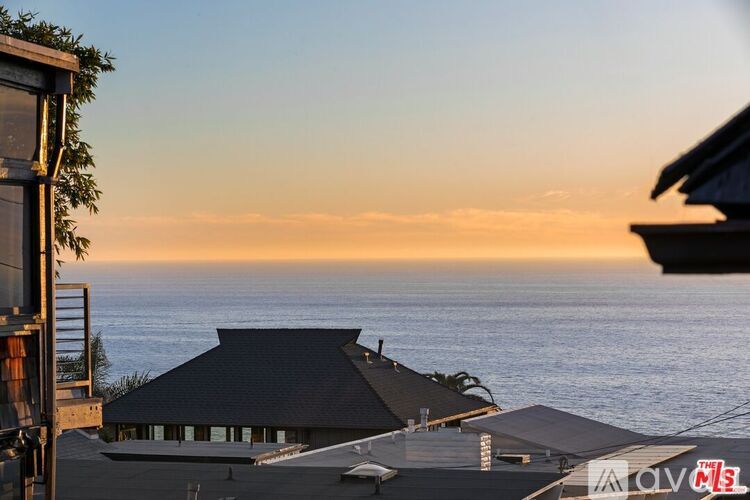 A house overlooking the ocean at sunset.
