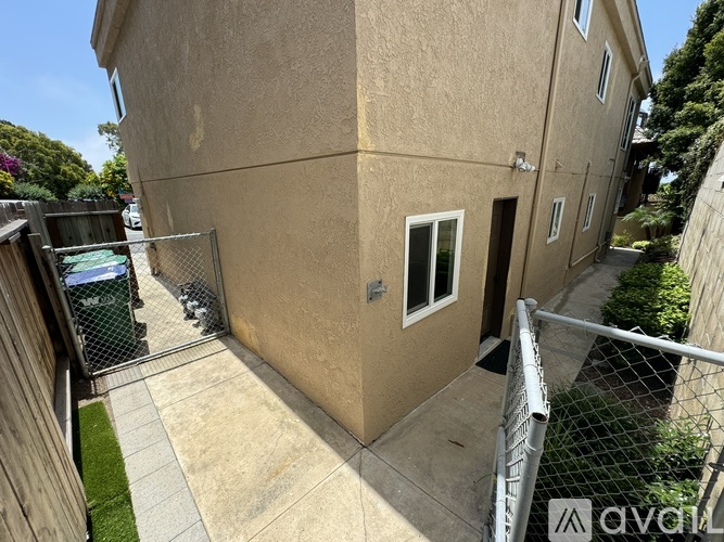 A beige building with a metal fence in front.