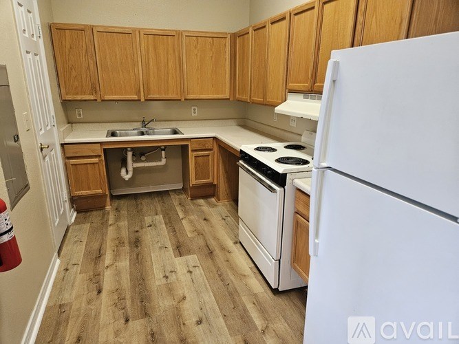 A kitchen with wooden cabinets and a white refrigerator.