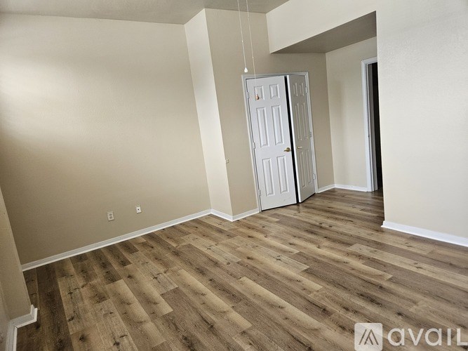 A room with wooden flooring and a white door.