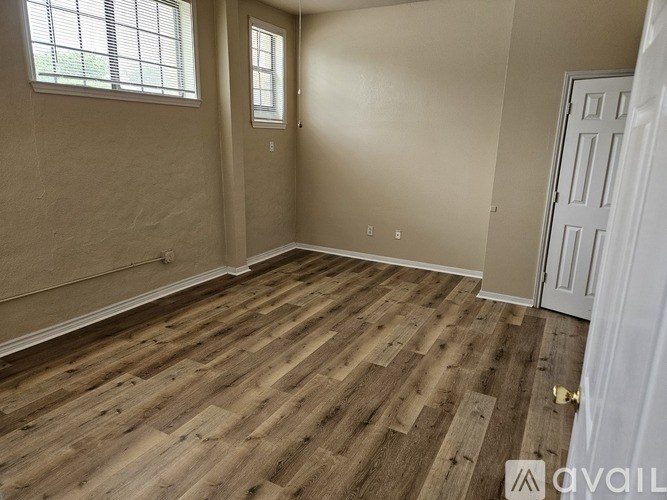 A room with wooden flooring and a white door.