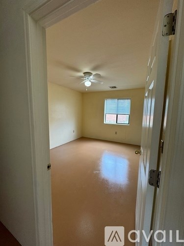 A room with a ceiling fan and a window.