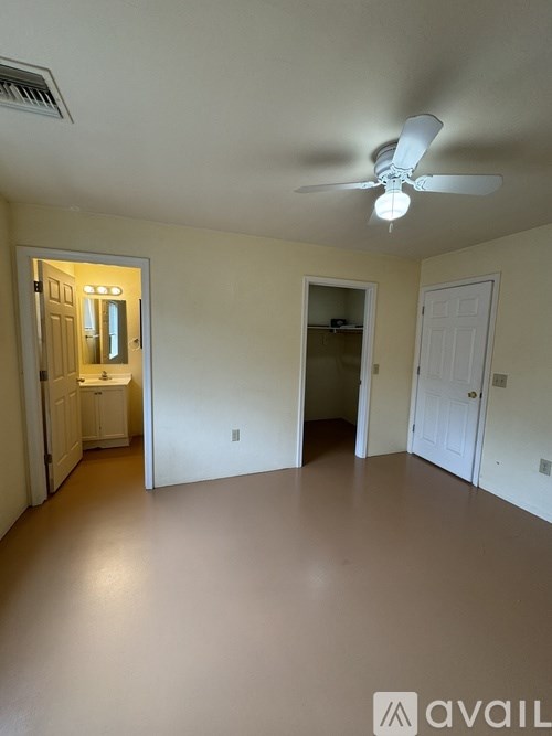 A room with a ceiling fan and two doors.