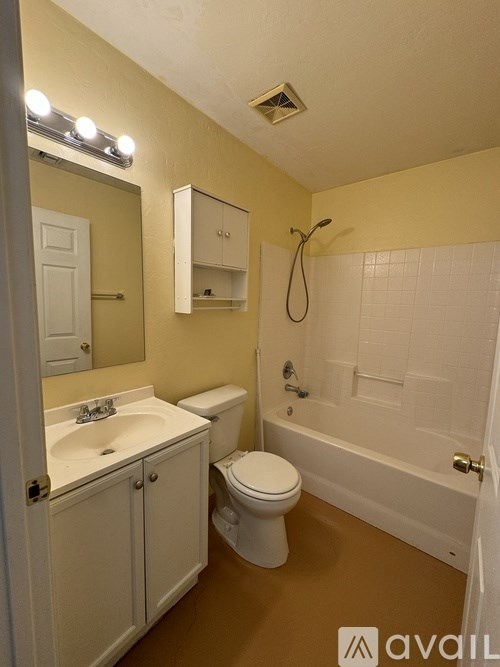 A bathroom with a toilet, sink, and bathtub.