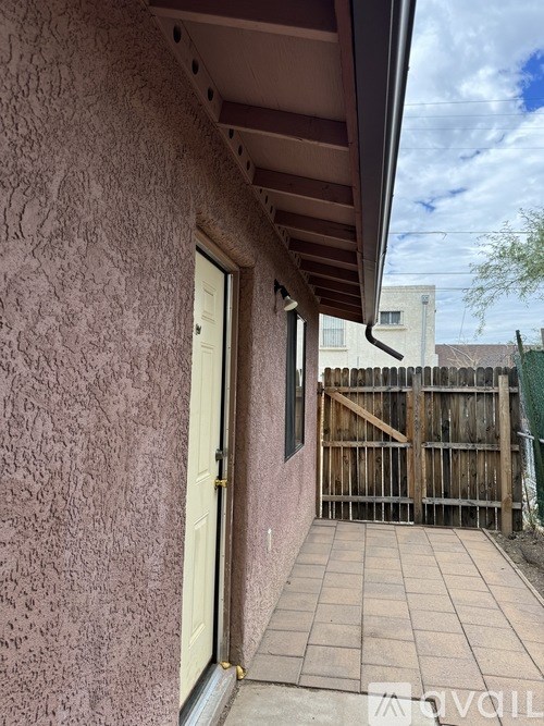 A pink wall with a wooden gate in the background.